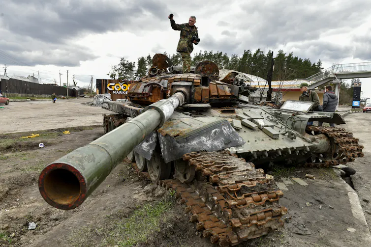 A man stands on destroyed Russian tanks in Buzova village of Kyiv area, Ukraine, 11 April 2022.