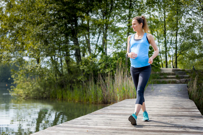 A pregnant woman enjoys a walk in the park.