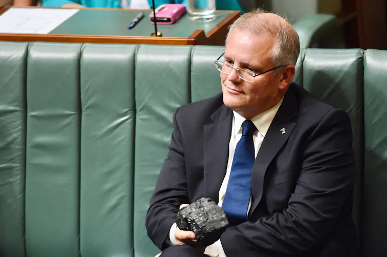 man holds lump of coal