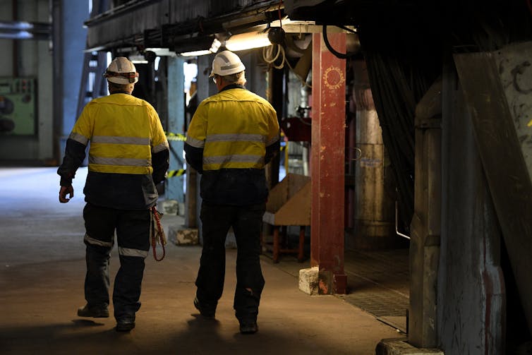 two men wearing high vis in industrial setting