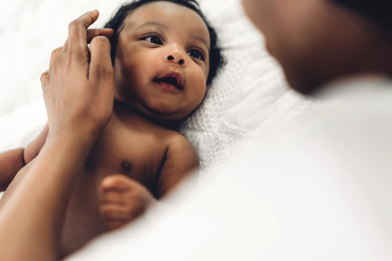 A woman playing with a baby.