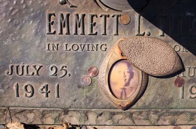 Grave stone featuring faded photograph of Black teenager.