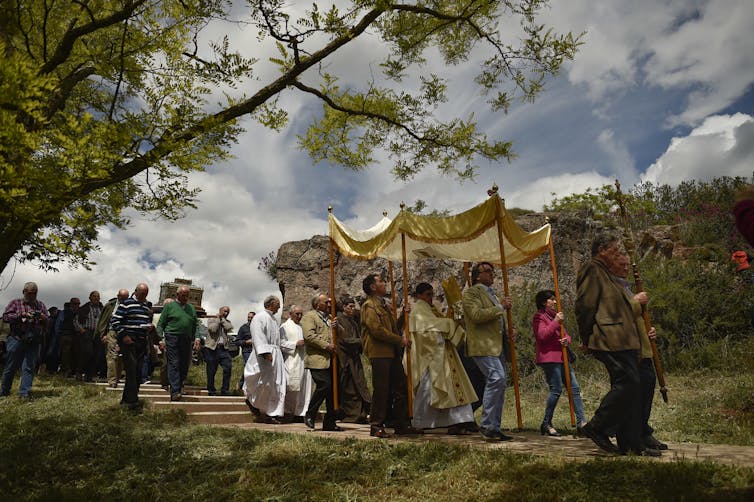 Devotees carrying the relic of Saint Gregory, in a procession through green fields in Sorlada, northern Spain.