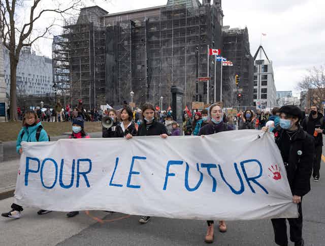 personnes tenant une pancarte "pour le futur" dans une manifestation
