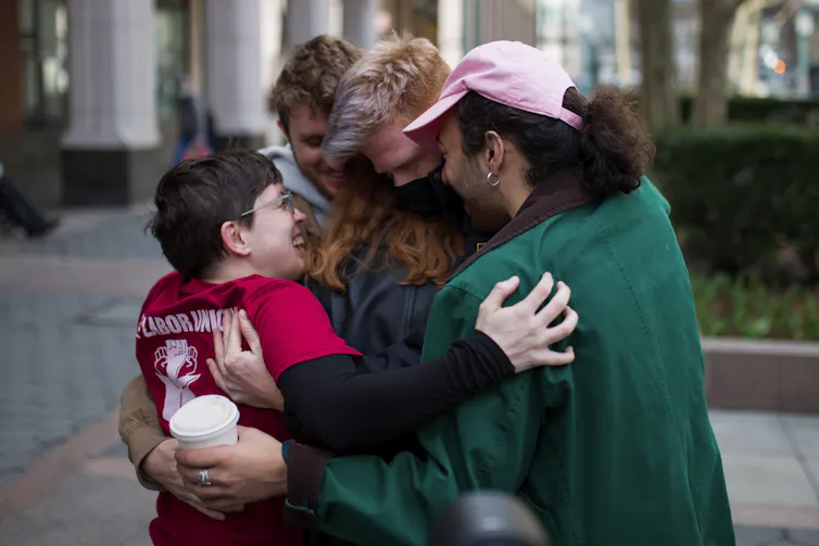A group of people hugging and smiling
