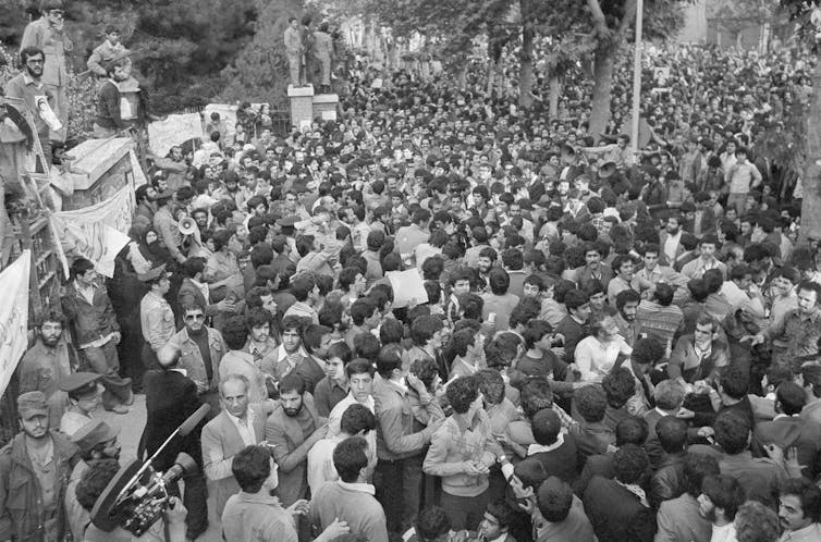 A large crowd of Iranian protesters press against the gates of the American embassy in Tehran in 1979