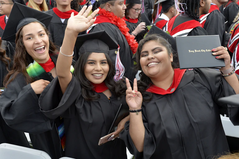 Three women of color attend their college graduation.