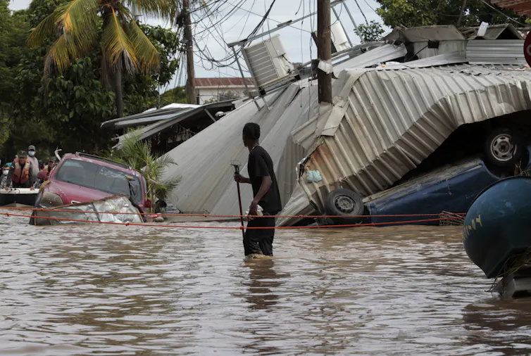 homme marche dans une rue inondée