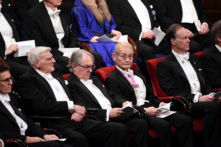 seated men wearing tuxedos