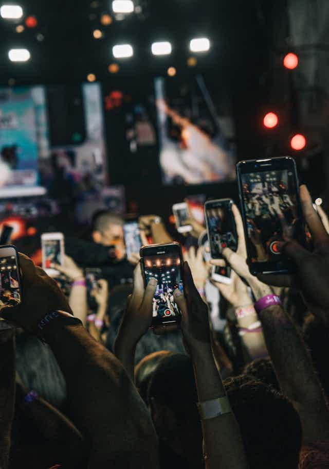 people holding mobile phones above their heads