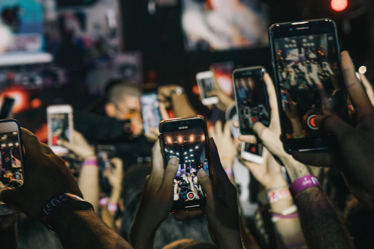 people holding mobile phones above their heads