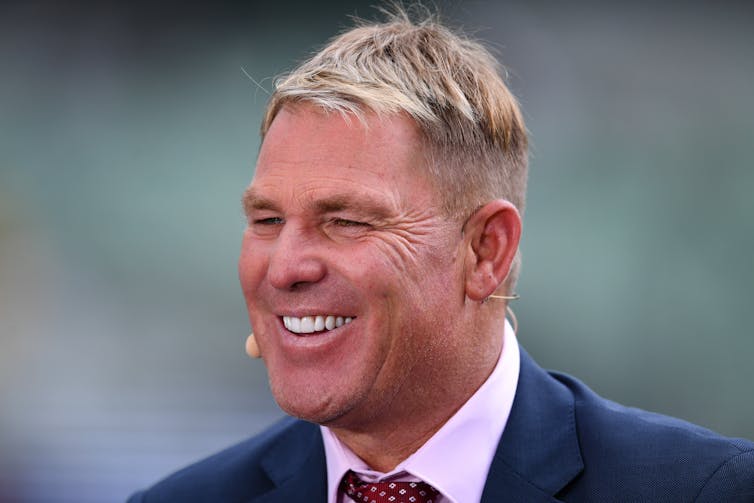 Shane Warne with presenter's microphone