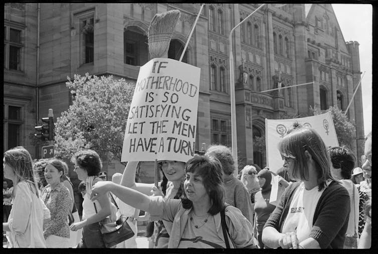 Protest sign reads: If motherhood is so satisfying let the men have a turn.