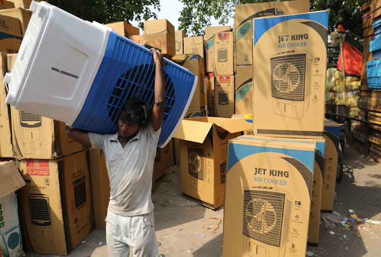 Man carries air cooler unit