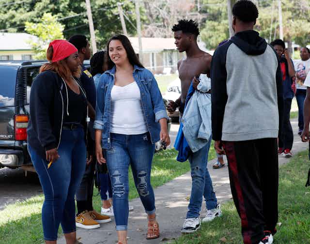 A group of young adults with varying skin tones socialize outside