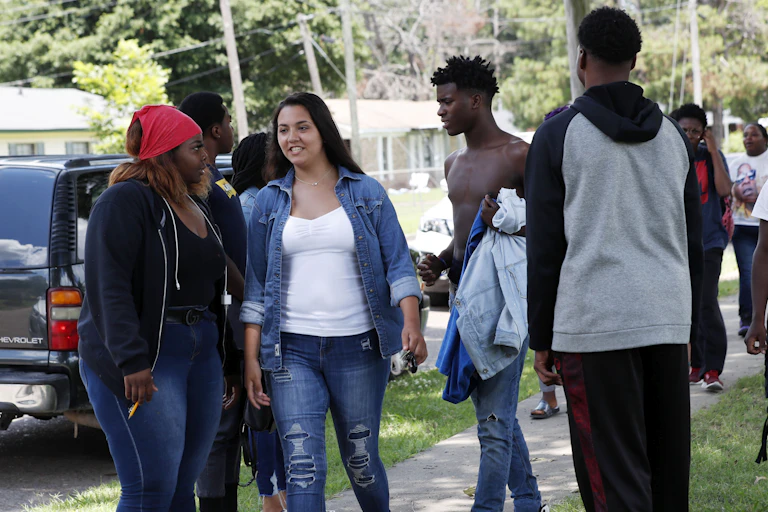 A group of young adults with varying skin tones socialize outside