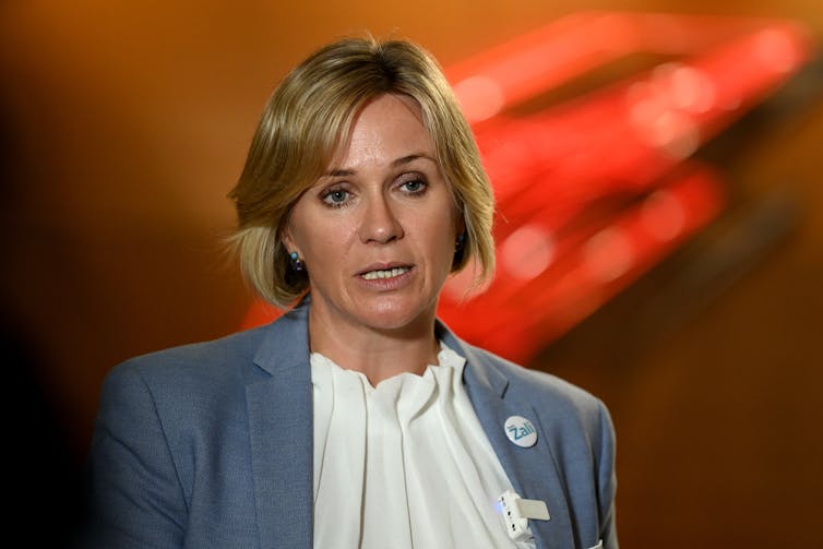 smartly-dressed woman with red background