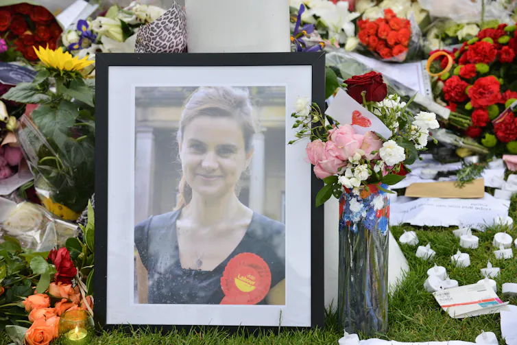 A photograph of a young woman is framed by bunches of flowers.