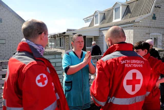 Ukrainian red cross workers with local residents at a town near Kyiv, April 2022.