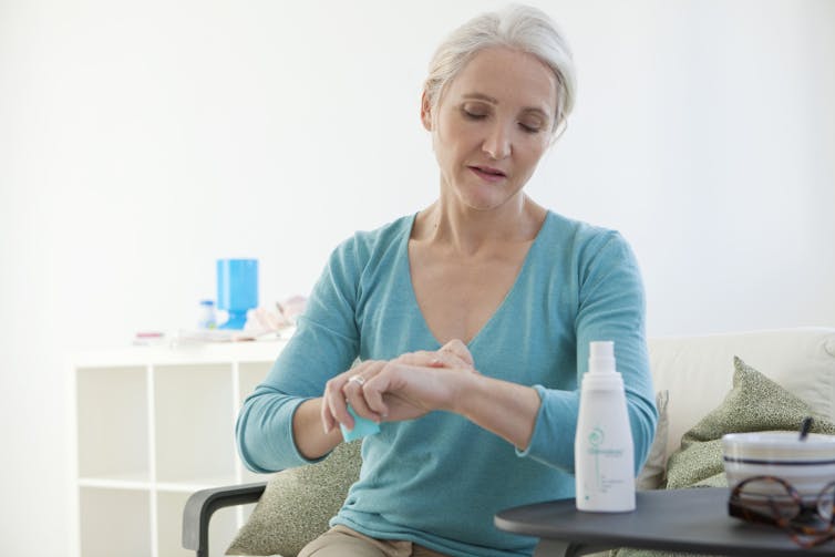 Woman uses HRT cream on her wrist.