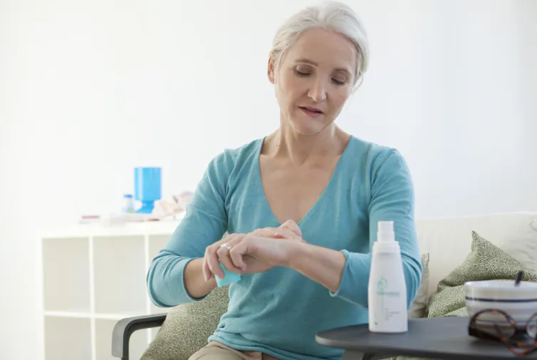 Woman applies HRT gel to her wrist.