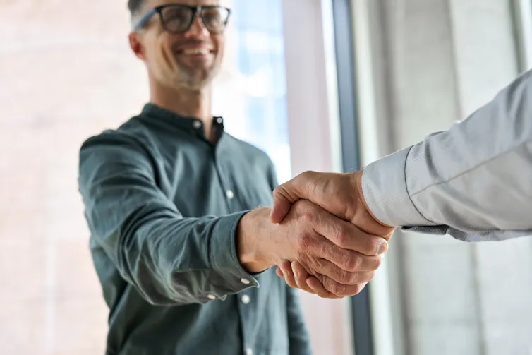 A man reaches out his hand to someone else