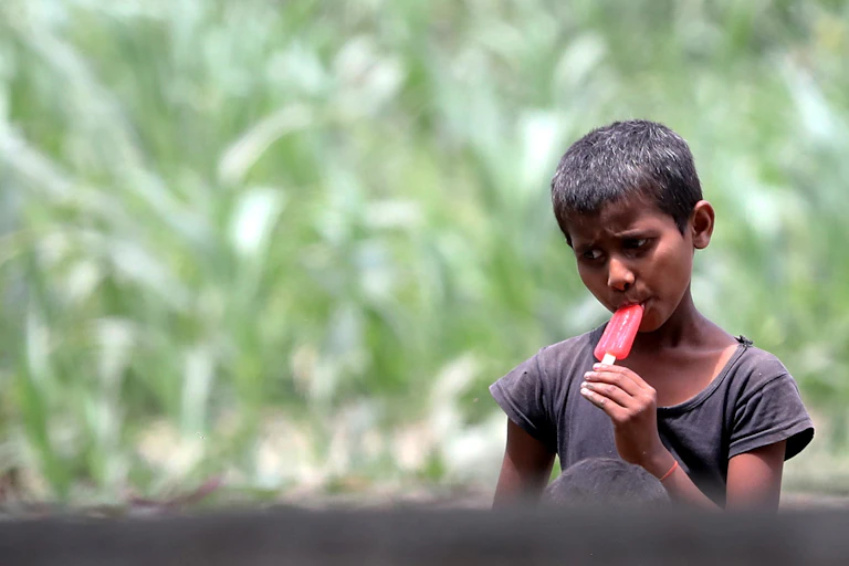 A boy eats an icy pole