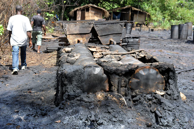 Men walking past burnt drums