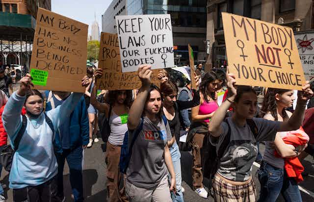 WOmen in new York march with placards bearing pro-choice slogans, April 2022.