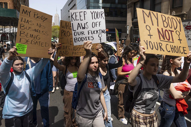 WOmen in new York march with placards bearing pro-choice slogans, April 2022.