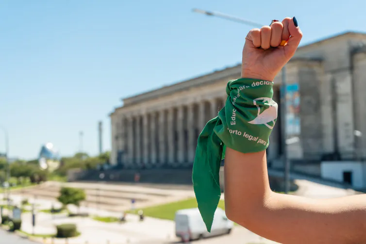 A woman's arm with a green wristband symbolising the fight for reproductive rights in Argentina.