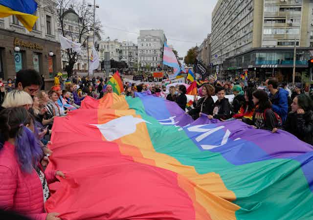 People hold a massive pride flag