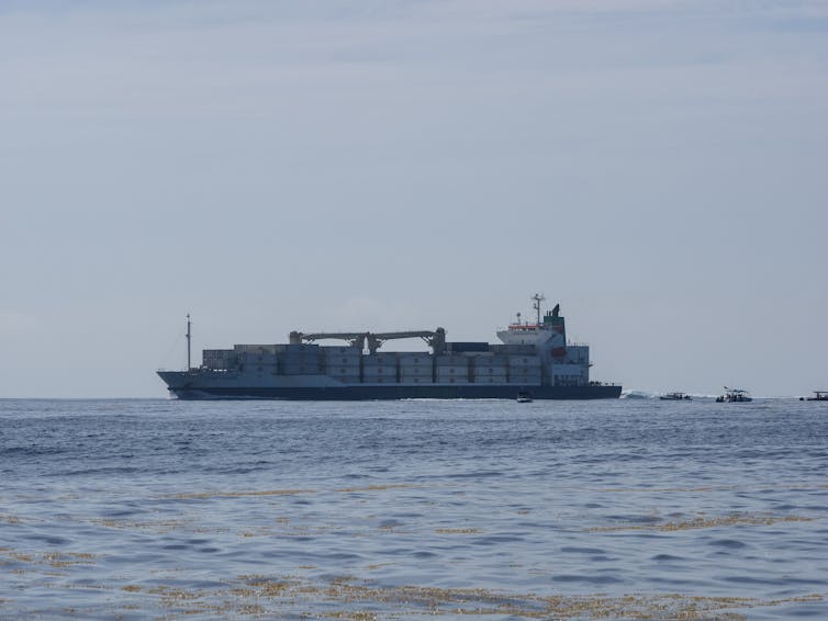 A large container vessel on the horizon.