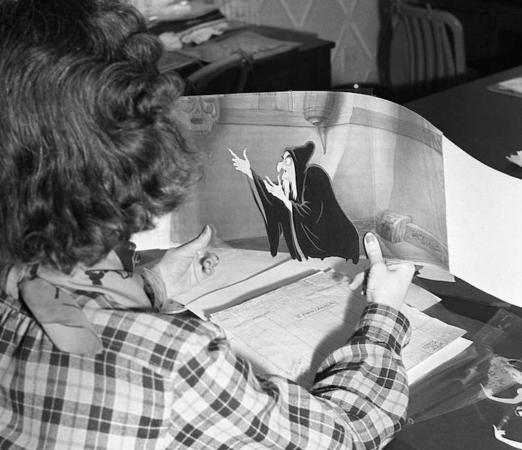 Woman holds cartoon drawing.