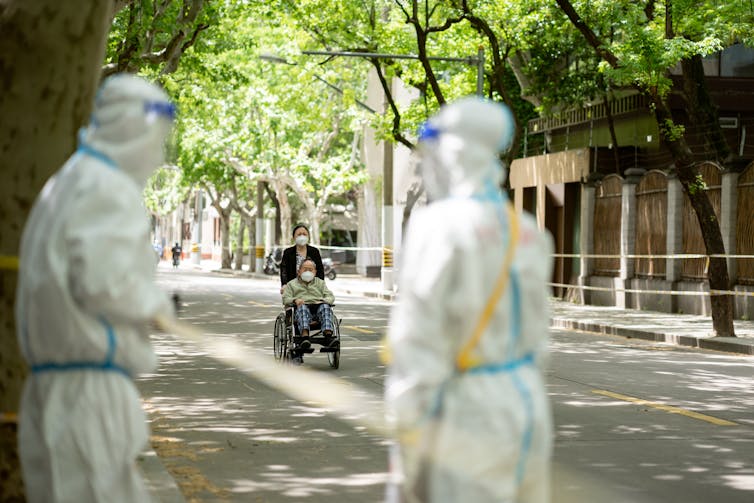 Elderly woman in a wheelchair in a Shanghai street