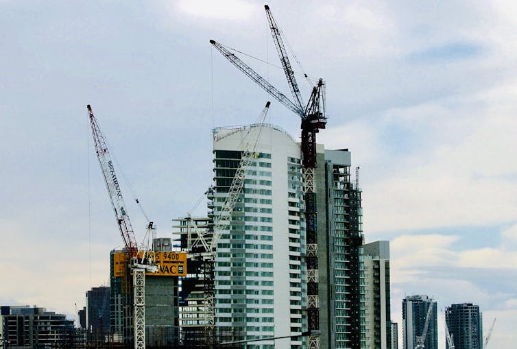 cranes in front of apartment construction
