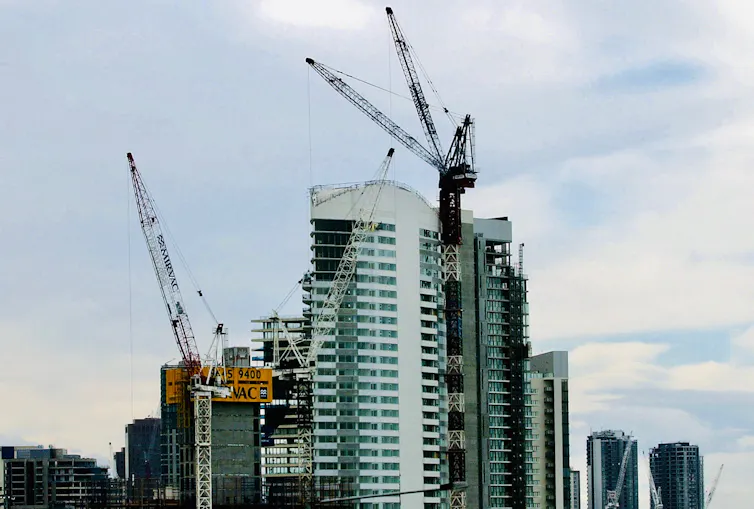 cranes in front of apartment construction