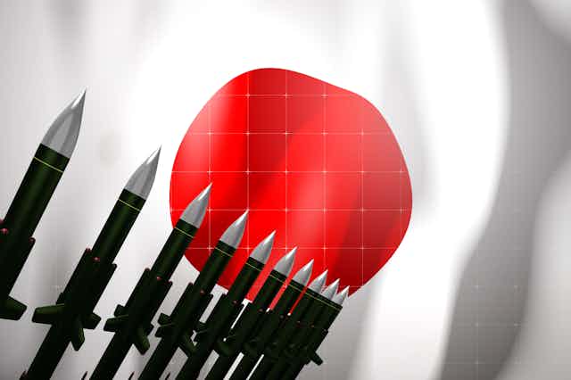 Illustration of Japanese rising sun flag with missiles in the foreground.