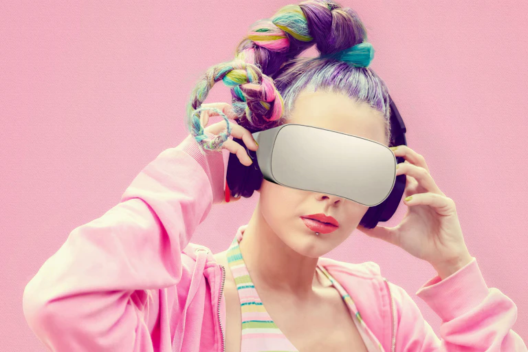 A young woman with multicoloured hair and a pink hoodie wears a VR headset.