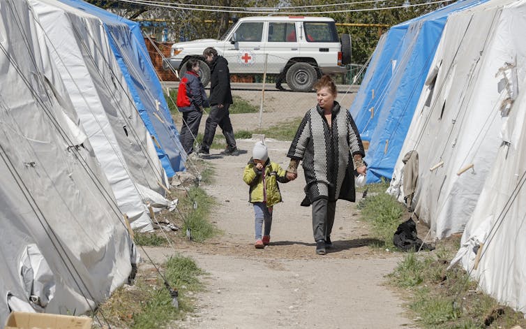 A woman and child evacuated from Azovstal, walk in the temporary accommodation centre in Bezimenoye village near Mariupol, Ukraine. May 7, 2022.