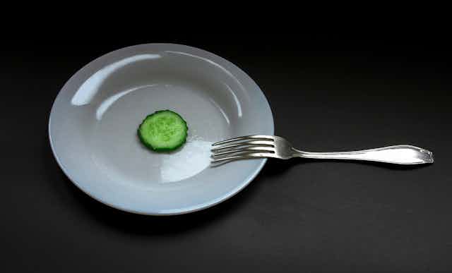 Assiette blanche avec une rondelle de concombre