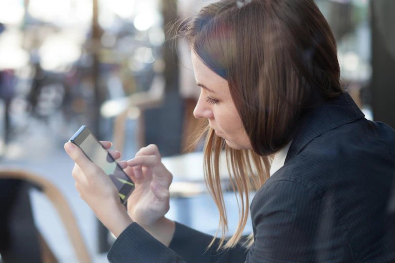Women using a smartphone outside a restaurant