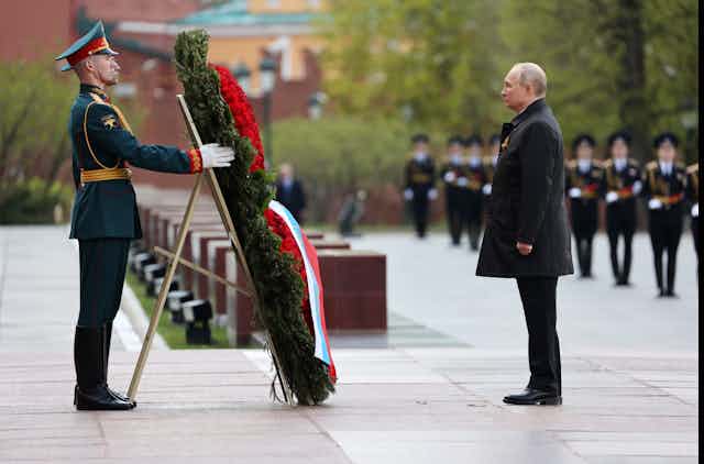 El presidente ruso, Vladímir Putin (d), asiste a una ceremonia de colocación de flores en la Tumba del Soldado Desconocido, junto al muro del Kremlin, tras el desfile militar del Día de la Victoria, en Moscú, Rusia, el 9 de mayo de 2022.