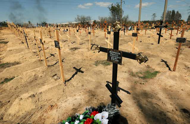 Rows and rows of wooden crosses on graves.