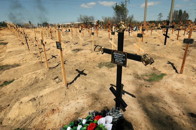 Rows and rows of wooden crosses on graves.