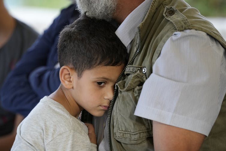 Un garçon est consolé par un homme âgé