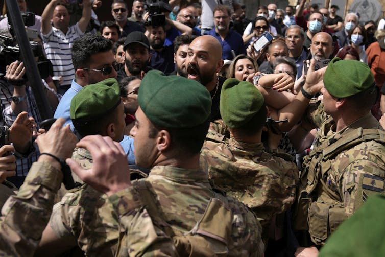 Des manifestants et des soldats se bousculent lors d’une manifestation, le 26 avril 2022. La crise financière et économique a plongé de nombreux libanais dans la pauvreté. (AP Photo/Hussein Malla)