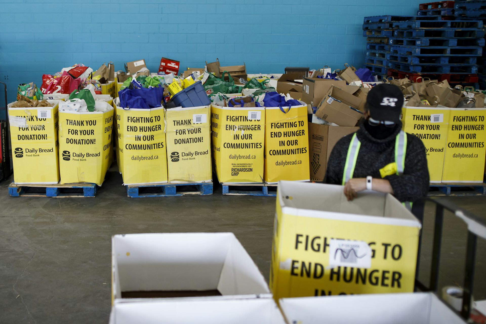 A volunteer organizing cardboard boxes at a food bank.