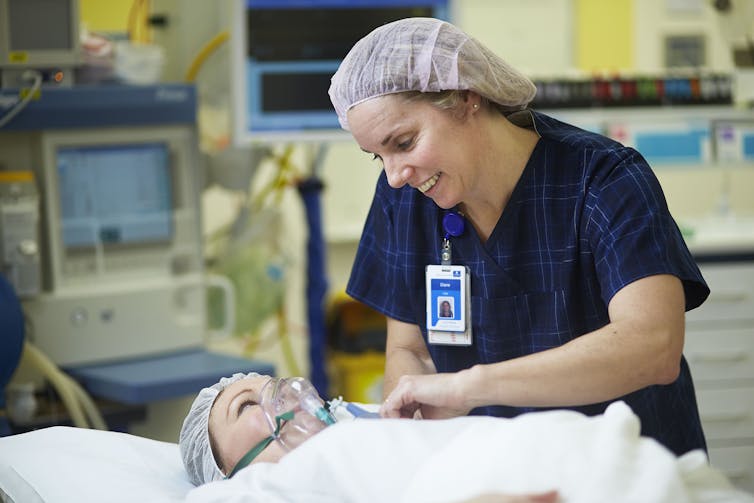 Nurse caring for woman on hospital gurney