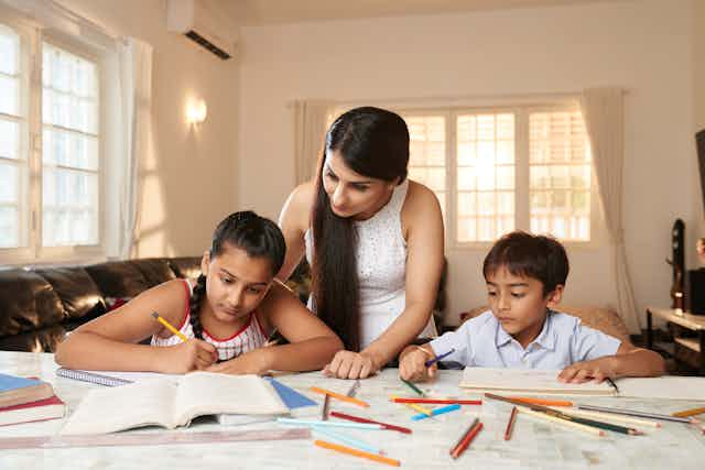 Mother supervising children doing homework